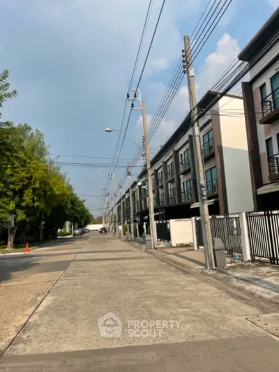 Modern townhouse row with clear sky and street view