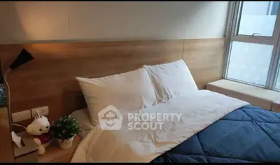 Cozy bedroom with modern decor and large window for natural light.