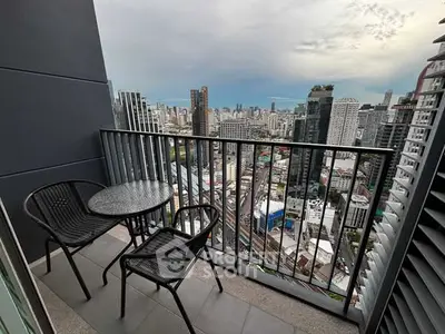 Stunning cityscape view from a modern high-rise balcony with seating area.