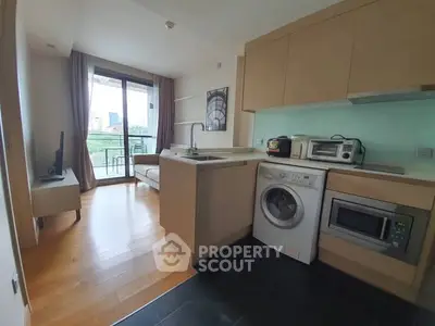 Modern open-layout kitchen with washing machine and balcony view