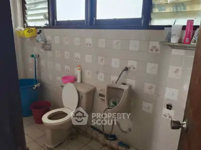Cozy bathroom with tiled walls and essential fixtures, perfect for a comfortable living space.
