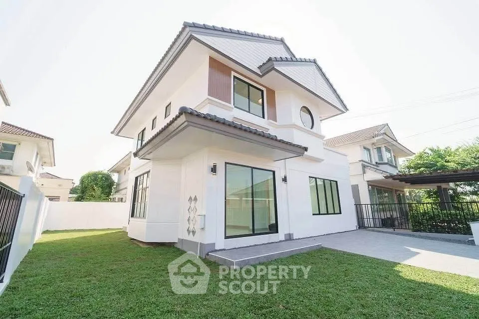 Modern two-story house with spacious lawn and large windows