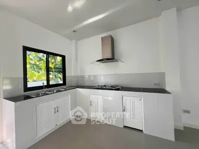 Modern kitchen with sleek cabinetry and gas stove in a bright, airy space.