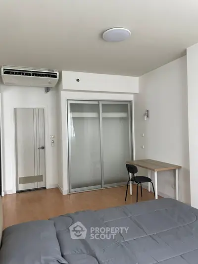 Modern bedroom with sleek design, featuring a cozy bed, minimalist desk, and built-in closet.