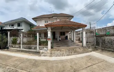 Charming two-story house with tiled roof and spacious driveway in a serene neighborhood.
