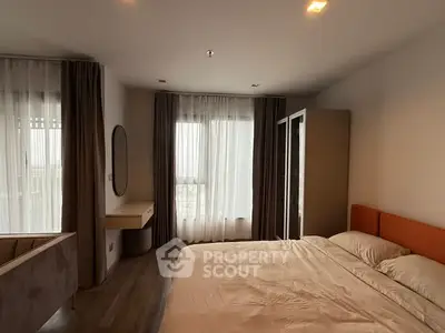 Modern bedroom with large windows and stylish furnishings