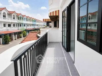 Charming townhouse balcony with scenic view of red-roofed neighborhood, perfect for relaxing outdoors.