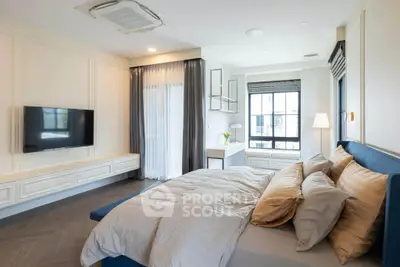 Luxurious bedroom with elegant decor, large window, and modern furnishings in a stylish apartment.