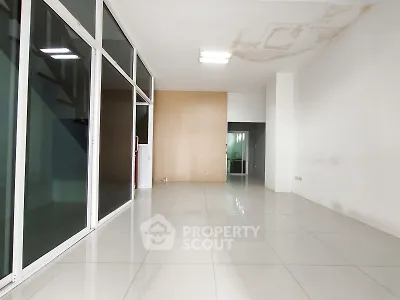 Spacious empty room with large windows and modern tile flooring