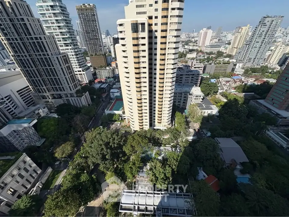 Stunning cityscape view from high-rise building showcasing urban architecture and lush greenery.