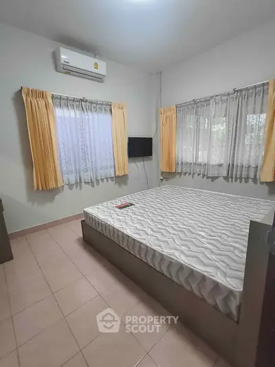 Cozy bedroom with air conditioning and natural light, perfect for relaxation.