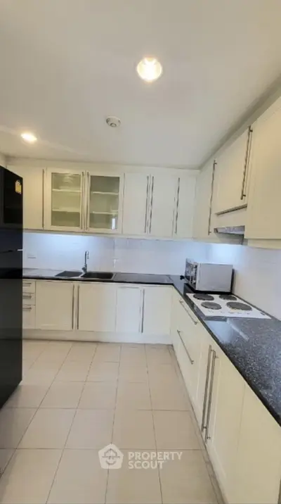 Modern kitchen with sleek white cabinets and black countertops