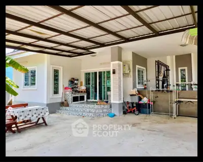 Charming outdoor patio with covered seating area and modern design, perfect for relaxation and entertaining.