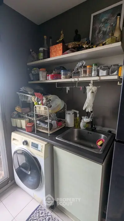 Compact kitchen with washing machine and sink, ideal for efficient urban living.