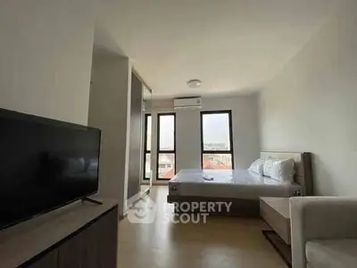 Spacious modern bedroom with natural light and stylish furnishings.
