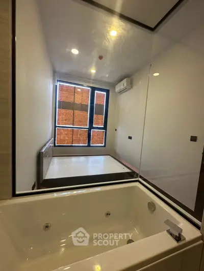 Modern bathroom with luxurious bathtub and large window for natural light.