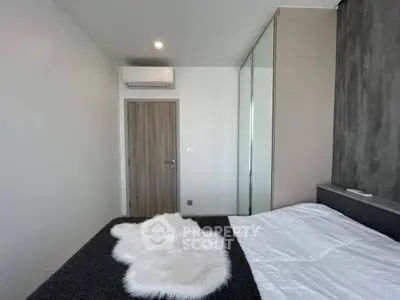 Modern bedroom with sleek design, featuring a cozy bed and stylish decor.