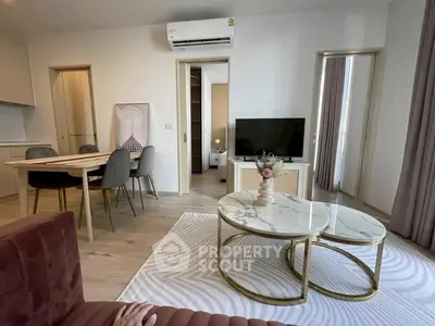 Modern living room with stylish furniture and open layout, featuring a cozy dining area and elegant decor.
