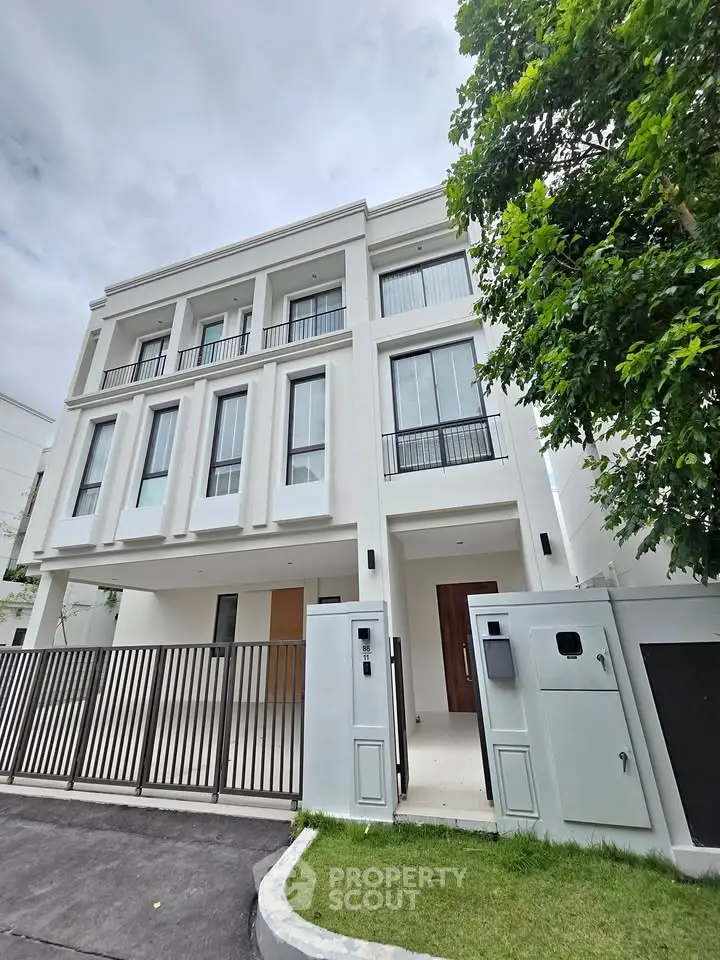 Elegant modern three-story townhouse with sleek facade and lush greenery, perfect for urban living.