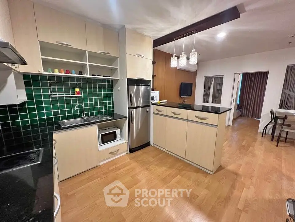 Modern kitchen with open layout and stainless steel appliances in stylish apartment.