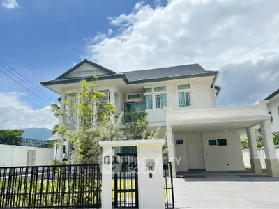 Stunning modern two-story house with spacious driveway and lush greenery under a bright blue sky.