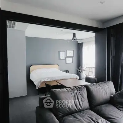 Modern open-plan bedroom with stylish decor and cozy seating area