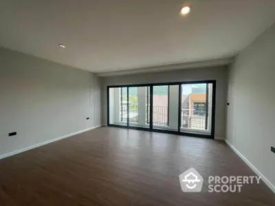 Spacious modern living room with large windows and balcony view