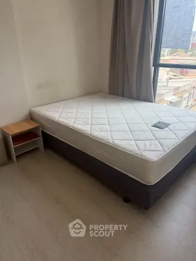 Cozy bedroom with large window and comfortable bed in modern apartment.