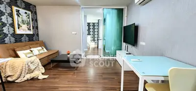 Modern living room with stylish decor and glass partition leading to bedroom
