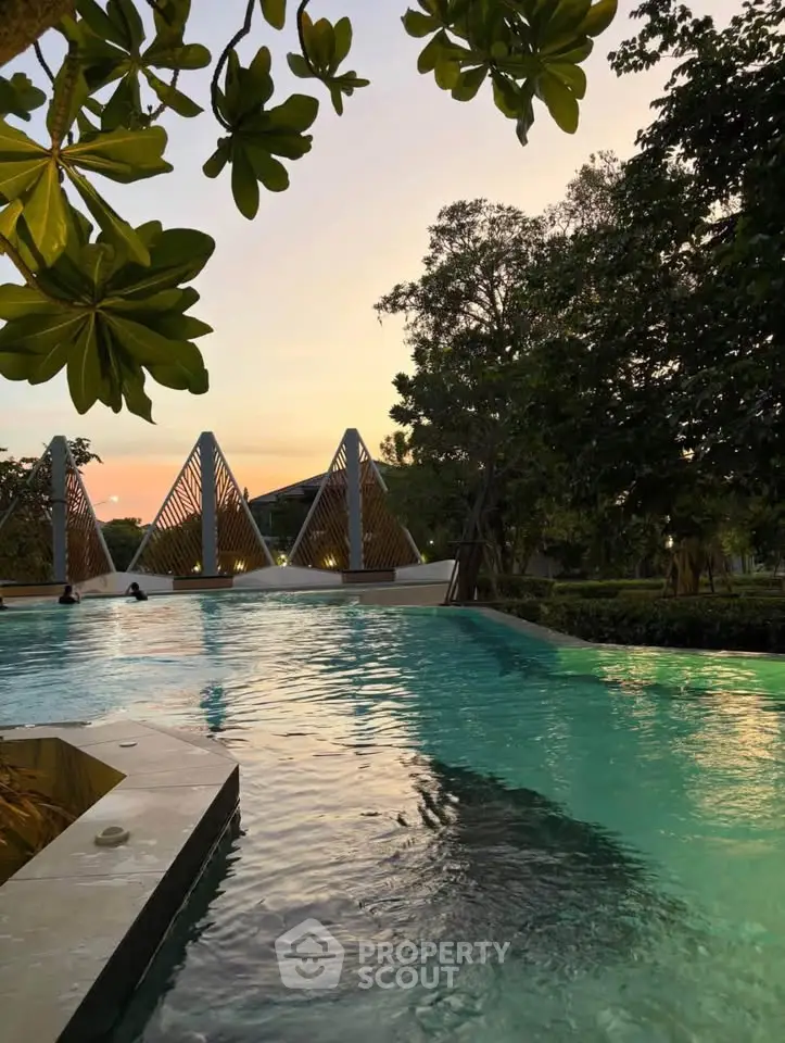Luxurious outdoor pool area with modern architectural features and lush greenery at sunset.
