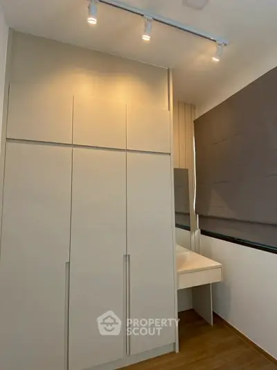 Modern minimalist bedroom with built-in wardrobe and sleek design.