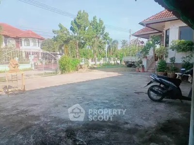Spacious residential driveway with lush greenery and charming house exterior