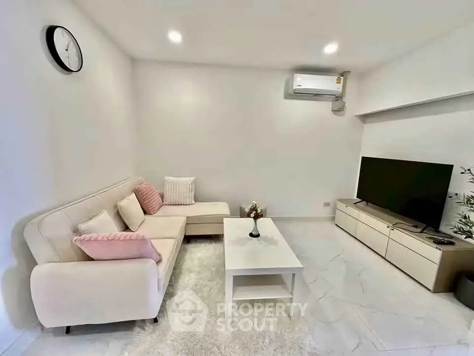 Modern living room with cozy sofa, stylish decor, and sleek TV setup.