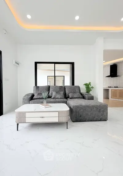 Modern living room with sleek gray sofa and elegant white marble flooring, featuring ambient lighting and open layout.