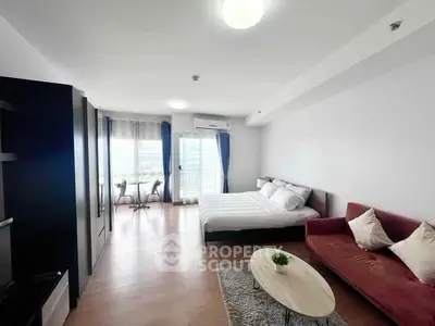 Spacious modern bedroom with cozy seating area and natural light