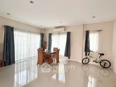Spacious living room with dining set and natural light