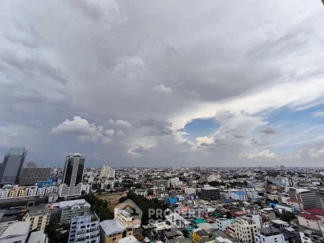 Stunning cityscape view from high-rise building showcasing urban skyline under dramatic clouds.