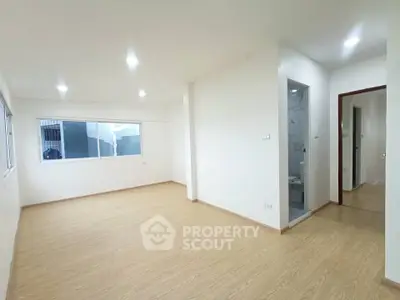 Spacious unfurnished living room with wooden flooring and large window