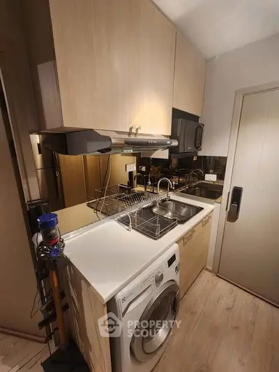 Compact modern kitchen with washing machine and sleek cabinetry