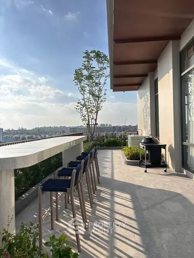 Spacious balcony with seating and BBQ, offering stunning city views.