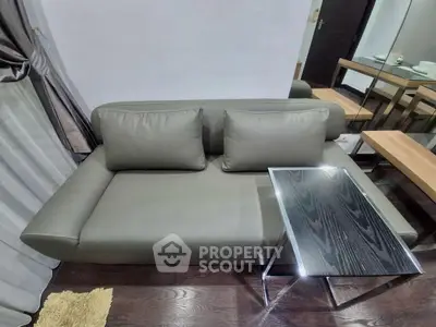 Modern living room with sleek gray sofa and stylish glass table