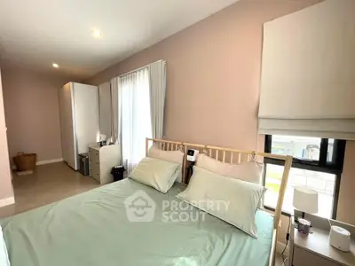 Spacious bedroom with natural light and modern decor, featuring a comfortable bed and stylish furnishings.