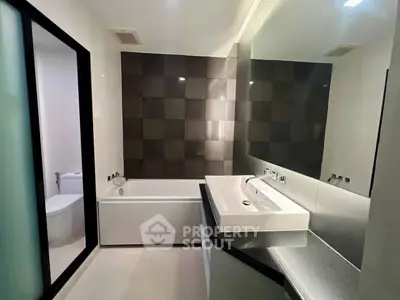 Modern bathroom with sleek design and bathtub in contemporary home.