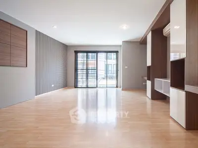 Spacious modern living room with wooden flooring and large windows.