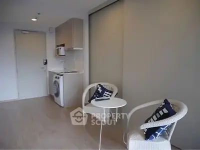 Modern studio apartment with compact kitchen and cozy seating area