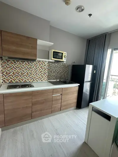 Modern kitchen with wood cabinets, mosaic backsplash, and balcony view