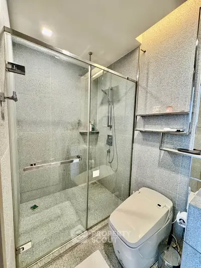 Modern bathroom with glass shower enclosure and sleek fixtures