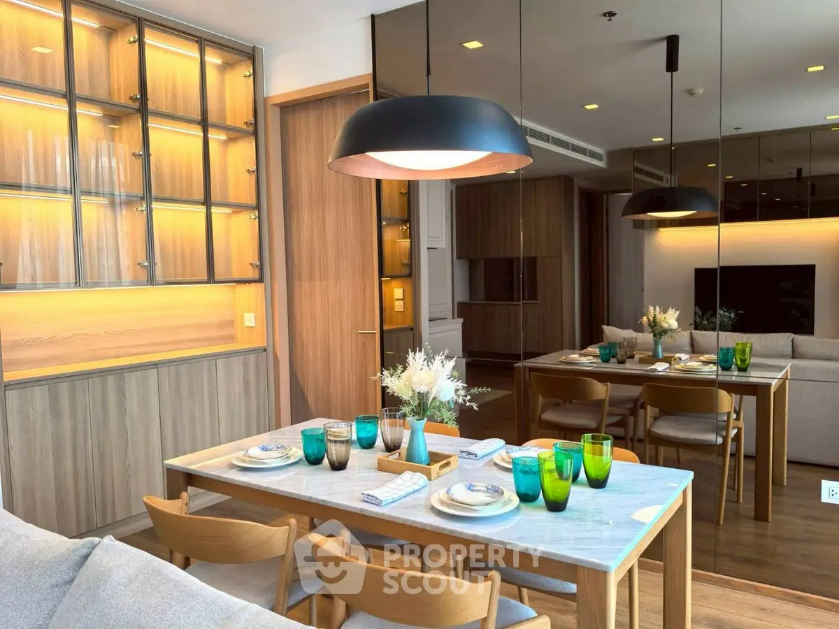 Modern dining area with elegant table setting and stylish lighting in a cozy apartment.