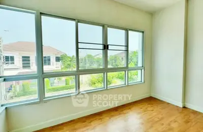 Bright empty room with large windows and wooden flooring, perfect for customization.
