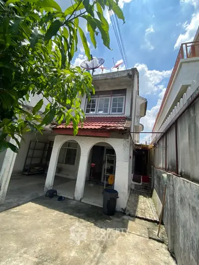 Charming two-story house with rustic exterior and lush greenery, perfect for family living.